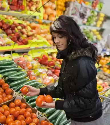 Woman shopping in the produce aisle.