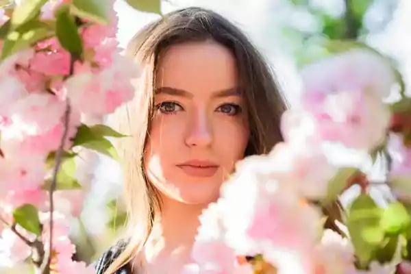 Pretty woman surrounded by pink flowers.