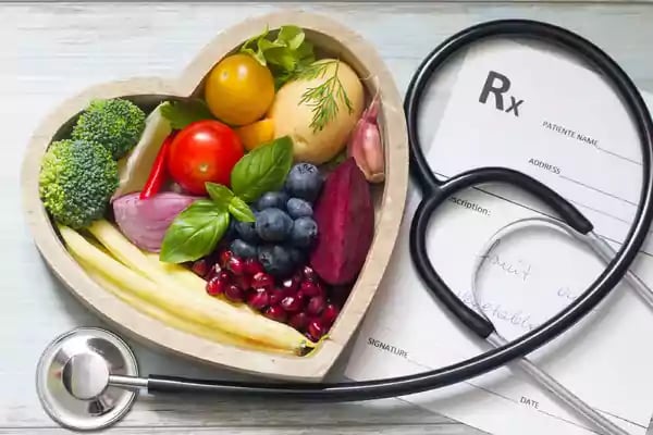 Heart shaped box filled with fruits and vegetables.