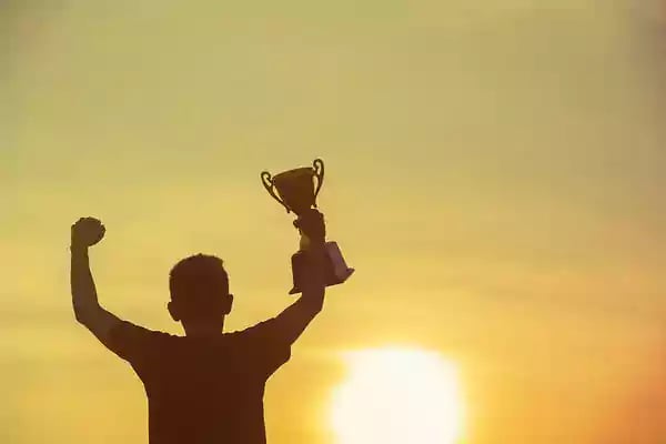 Man holding a trophy in triumph.