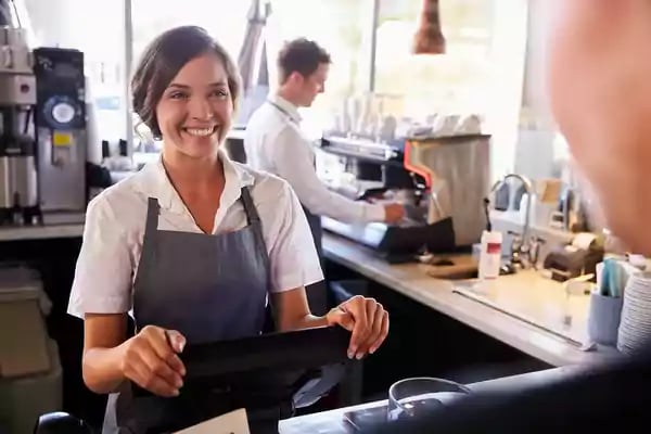 Woman taking an order at a coffee shop.