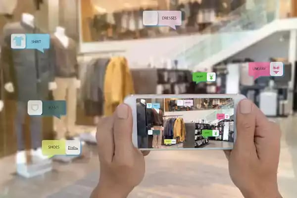 Person holding a phone in a clothing store.