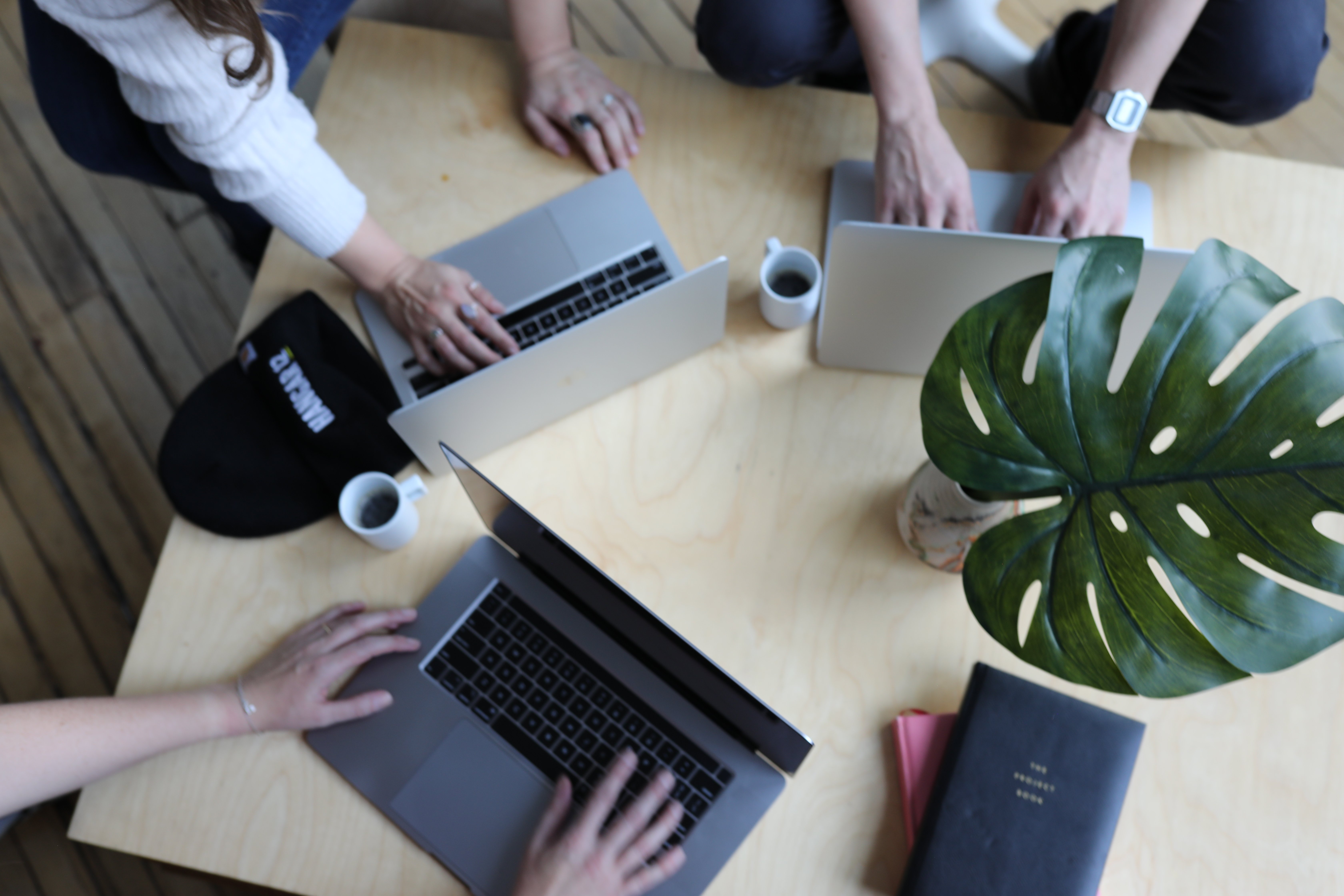 Overhead view of a team collaborating around a table with laptops