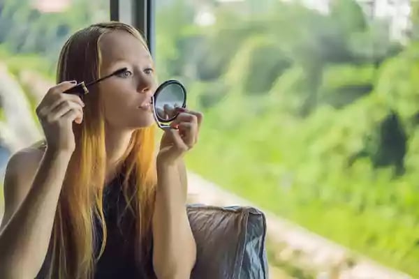 Woman putting mascara on.